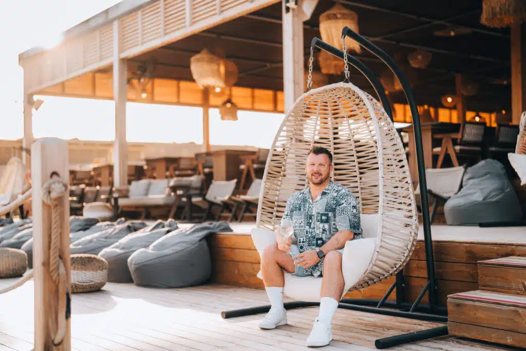 Gast entspannt in einem Hängesessel in der Strandlounge