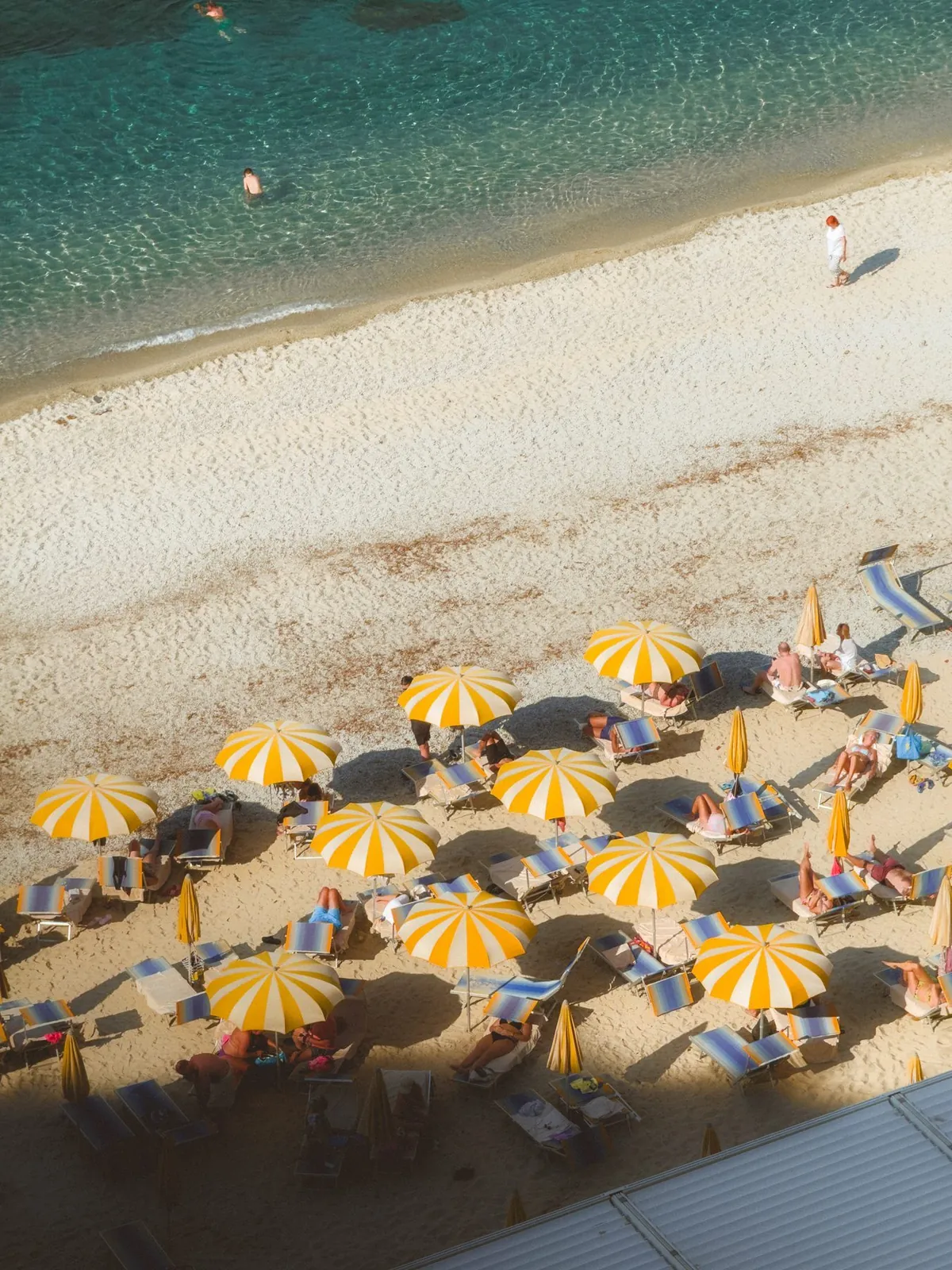 Strand mit gelben Schirmen von oben