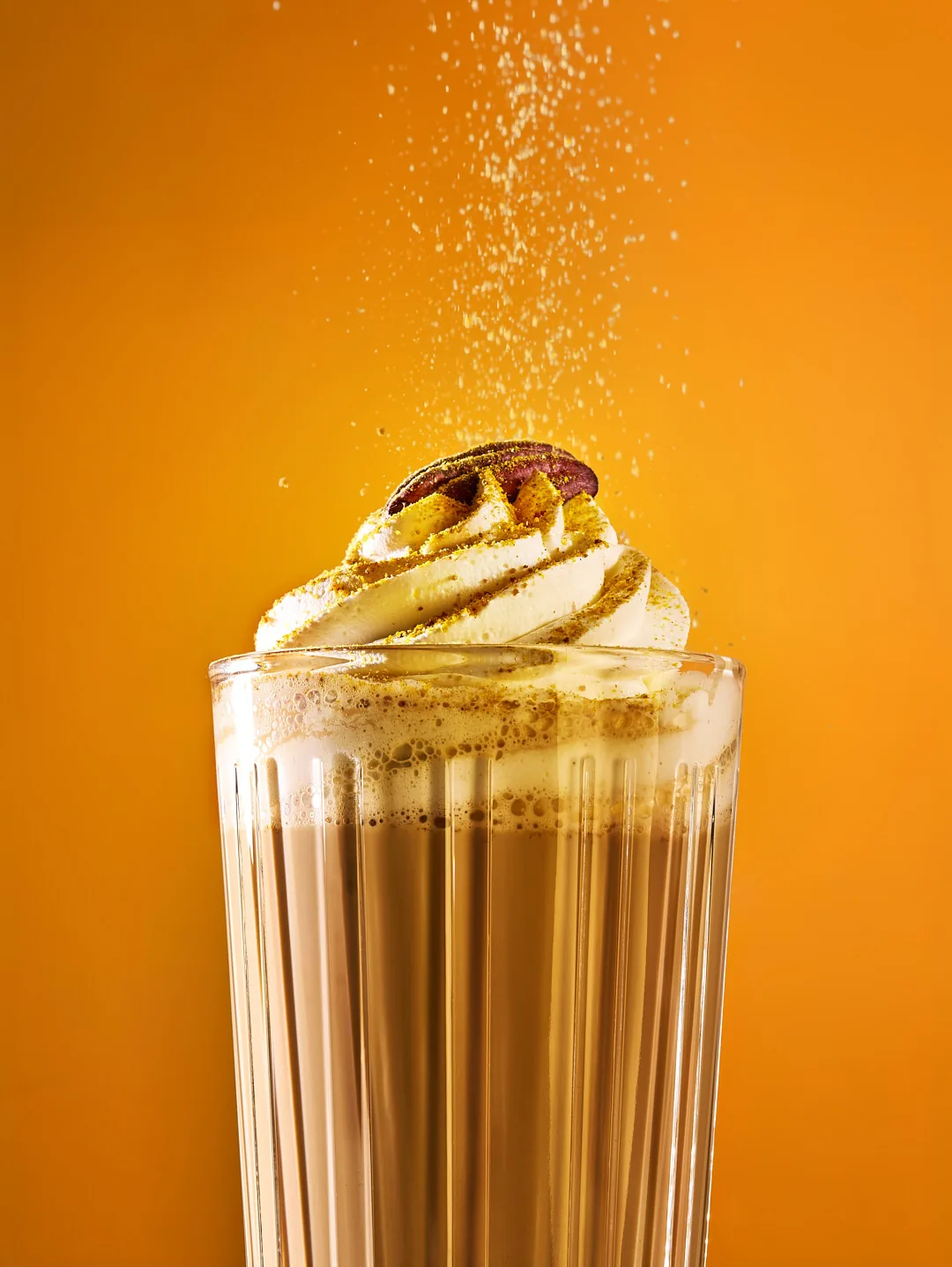 Latte mit Sahnehaube und Pekannuss