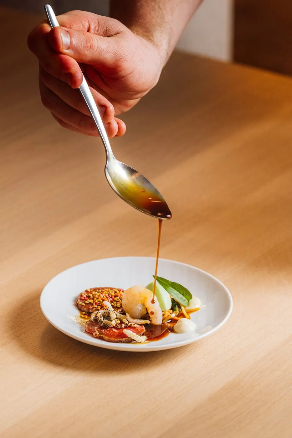 Sauce wird auf einen Teller angerichtet