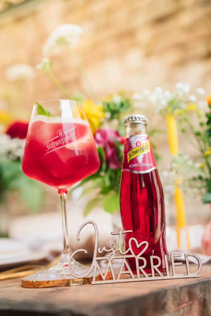 Pinker Drink zur Hochzeit mit einer Flasche Schweppes