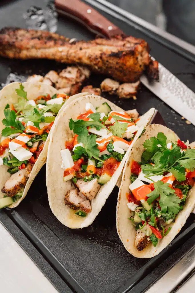 Drei gefüllte Tacos auf einem Brett