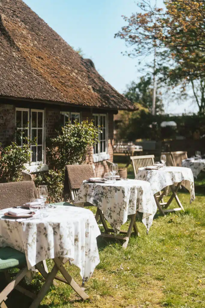 Gedeckte Tische im Garten eines reetgedeckten Hauses auf Fanø