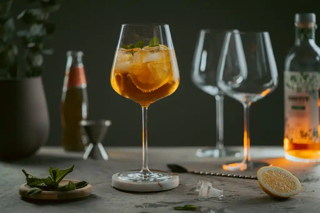 Alkoholfreier Spritz im Weinglas neben leeren Gläsern
