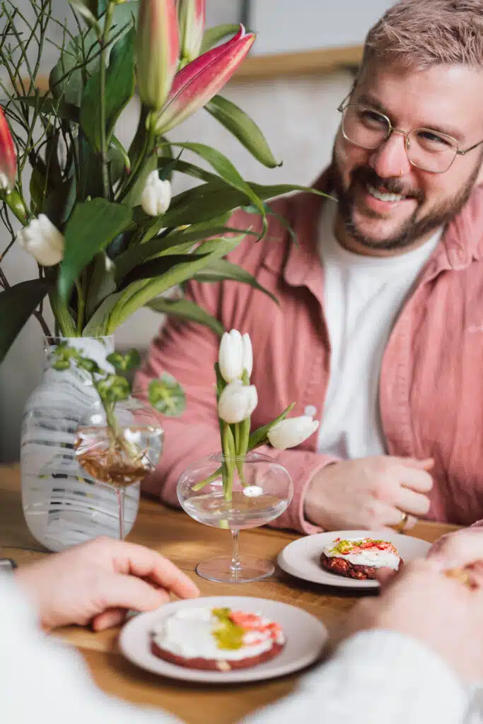Gast am gedeckten Tisch mit Dessert in Gläsern